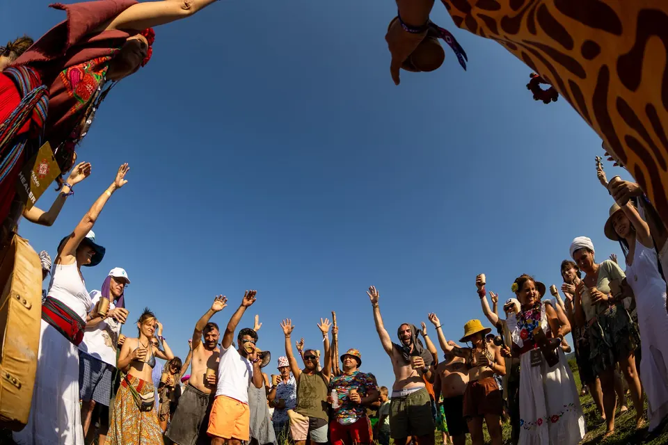 Hands reach to the sky in a ceremony circle